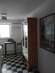 a room with a cabinet and a checkered floor at Warszawa Apartament z Widokiem in Warsaw