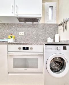 uma cozinha branca com máquina de lavar e secar roupa em apartament Eliette 4 em Bagá