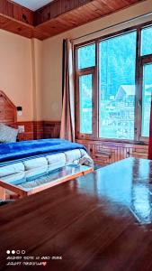 1 dormitorio con 2 camas y ventana grande en Wood packers en Kasol