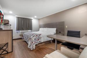 a hotel room with a bed and a desk at Red Roof Inn Suffolk in Suffolk