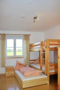 a bedroom with two bunk beds and a window at Granerhof Ferien in Peißenberg