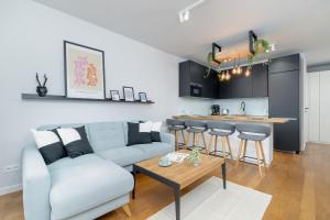 a living room with a couch and a table and a kitchen at Ślusarska Modern Apartment with Balcony & Parking Cracow Zabłocie by Renters Prestige in Krakow