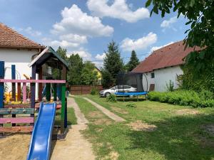 a playground with a slide in a yard at Sárdoár Vendégház in Abádszalók