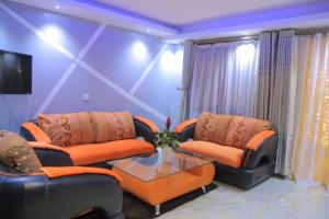 - un salon avec deux canapés et une table dans l'établissement Perla Hotel, à Kampala