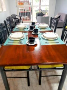una mesa de madera con platos y tazas. en Llanitos de Aurora, en Ibagué