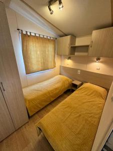 une chambre avec deux lits et une fenêtre dans l'établissement Mobilhome 3 chambres 6 personnes près de la plage - Novela - Frédéric et Sandra, à Port-la-Nouvelle 16 autres photos