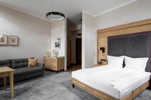 a bedroom with a bed and a couch at Aparthotel Cristina in Zakopane