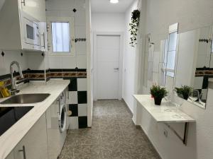 een witte keuken met een wastafel en een spiegel bij Sweet Home Center Beatas in Málaga +18 foto's