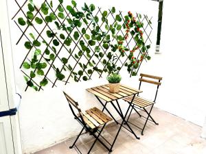 een muur met een tafel, stoelen en een plant bij Sweet Home Center Beatas in Málaga