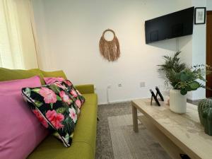 een woonkamer met een groene bank en een tafel bij Sweet Home Center Beatas in Málaga