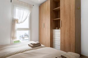 sypialnia z 2 łóżkami i oknem w obiekcie Apartamento María Conil Bajo w mieście Conil de la Frontera