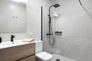 ein Badezimmer mit Dusche, Toilette und Waschbecken in der Unterkunft Apartamento María Conil Bajo in Conil de la Frontera + 13 Fotos