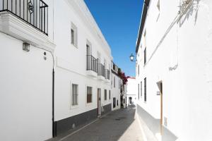 alejka z białymi budynkami i niebieskim niebem w obiekcie Apartamento María Conil Bajo w mieście Conil de la Frontera