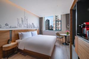 a hotel room with a white bed and a window at UrCove by HYATT Shanghai Jing'An in Shanghai