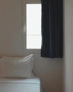 a bedroom with a window and a bed with a pillow at Vegas Residence in Albufeira