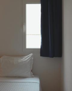 um quarto com uma janela e uma cama com uma almofada em Vegas Residence em Albufeira
