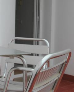 una sedia di metallo con tavolo e tavolo di Vegas Residence ad Albufeira
