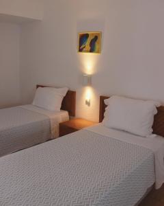 a hotel room with two beds and a lamp at Vegas Residence in Albufeira