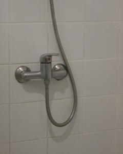 a shower head with a hose in a bathroom at Vegas Residence in Albufeira