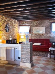 - un salon avec un canapé rouge et un mur en briques dans l'établissement Ca Giobbe, à Venise