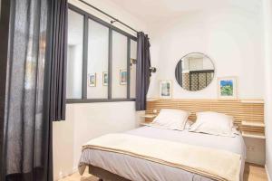 um quarto com uma cama com uma janela e um espelho em Cosy flat in the heart of Villefranche-sur-Mer em Villefranche-sur-Mer