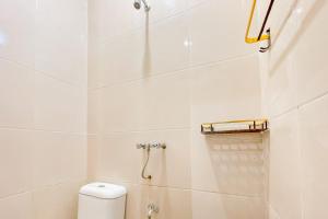 y baño blanco con ducha y aseo. en Urbanview Hotel Sany Cirebon en Tangkil