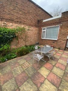 un patio con 2 sillas y una mesa frente a un edificio de ladrillo en 62 Sturry Road, en Canterbury
