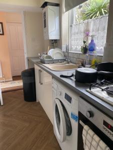 a kitchen with a washer and dryer on a counter at 62 Sturry Road in Canterbury