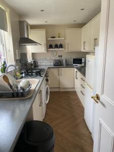 Una cocina con gabinetes blancos y un fregadero. en 62 Sturry Road, en Canterbury