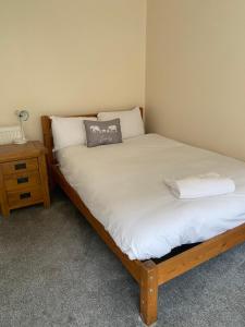 a bedroom with two beds and a night stand with a lamp at 62 Sturry Road in Canterbury