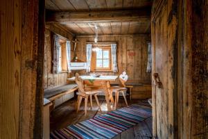 a dining room with a table and chairs in a cabin at Grossgasteigerhof in Selva dei Molini