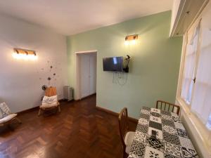 a dining room with a table and a tv on the wall at Departamento Mar del Plata in Mar del Plata