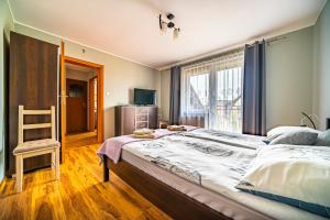 a bedroom with a large bed and a window at Jeżynowa 30 in Jastarnia
