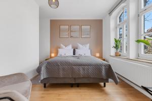 ein Schlafzimmer mit einem Bett und zwei Fenstern in der Unterkunft apart21 - Exklusive Apartments in zentraler Lage mit Parkplatz in Ingolstadt