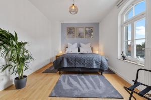 ein Schlafzimmer mit einem Bett und einer Topfpflanze in der Unterkunft apart21 - Exklusive Apartments in zentraler Lage mit Parkplatz in Ingolstadt