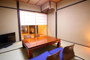 a dining room with a wooden table and chairs at And Machiya Inn in Kyoto