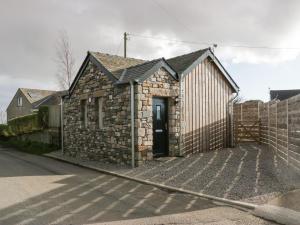 a small stone building with a door on a street at Driftwood Studio in Ulverston