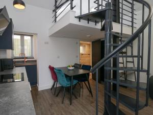 a kitchen and dining room with a spiral staircase at Driftwood Studio in Ulverston