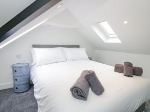 a bedroom with a white bed with towels on it at Driftwood Studio in Ulverston