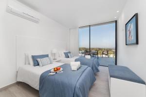 two beds in a white room with a balcony at Villa Natureza - By SCH in Serra do Bouro +36 photos
