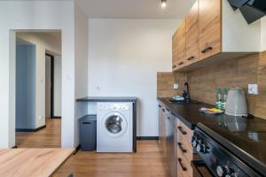 a kitchen with a washer and dryer in a room at Sosnowiec City Centre Apartment in Sosnowiec