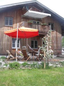a table and chairs under an umbrella in front of a house at Granerhof Ferien in Peißenberg