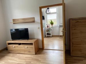 una sala de estar con TV en un tocador de madera en Ferienwohnung Fam. Falk, en Zeulenroda