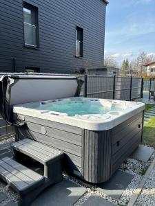 a jacuzzi tub in the yard of a house at Lux Apart - Apartamenty z jacuzzi i sauną nad Wisłą in Ustroń