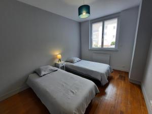 2 Betten in einem kleinen Zimmer mit Fenster in der Unterkunft Appartement cœur de ville in Beauvais