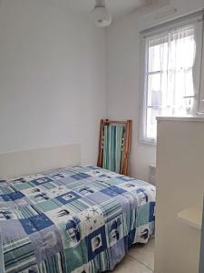 a bedroom with a bed with a blue and white quilt at Villa centre-ville proche plage -6264 in Soulac-sur-Mer