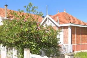 a white fence in front of a house with a tree at Villa centre-ville proche plage -6264 in Soulac-sur-Mer