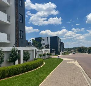 a street in a city with buildings and grass at Luxury 3 Bedroom Apartment in Carlswald in Erand