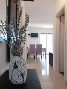 a white vase with flowers sitting on a table at Lovely 2-bedroom apartment Lavender in Milna