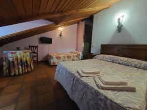 a bedroom with two beds with towels on them at Hostal restaurante Villa de Sepúlveda in Sepúlveda